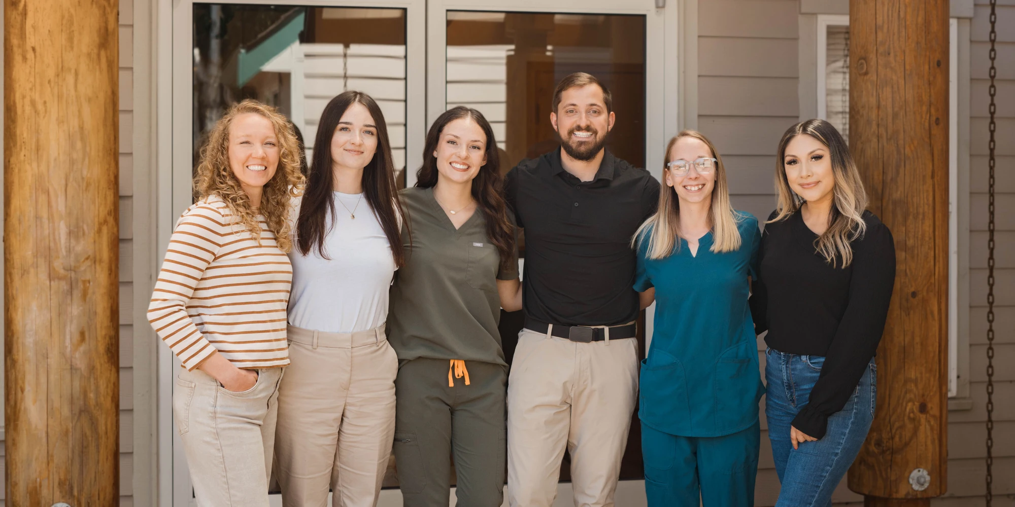 Chiropractor Olympia WA Nicholaus Martin Poses at Front Entrance with His Team Chiropractor Olympia WA Nicholaus Martin Poses at Front Entrance with His Team