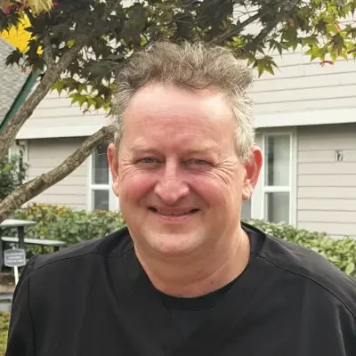 doctor in black tshirt smiling with platinum hair